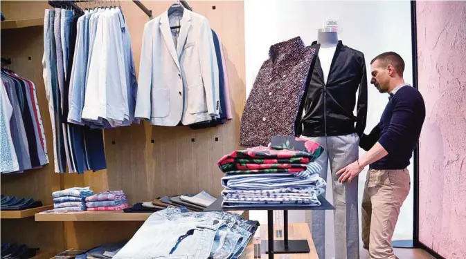  ?? —AP ?? NEW YORK: Bonobos manager Stephen Lusardi arranges clothing at the brand’s Guideshop, in New York’s Financial District. The US government issued the March jobs report on Friday.