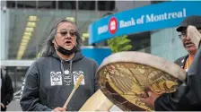  ?? DARRYL DYCK THE CANADIAN PRESS ?? Maxwell Johnson sings and drums outside a Bank of Montreal branch before a news conference in Vancouver on Thursday.