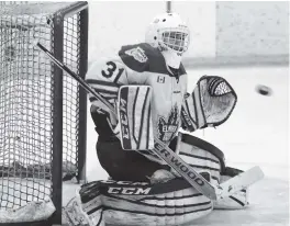  ?? [LIZ BEVAN / THE OBSERVER] ?? Elmira’s Jonathan Reinhart makes a save on Sunday night against Kitchener. Jeff Jordan tries to get the puck away from the Dutchmen.