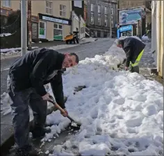  ??  ?? Council workers, Padraig McVeigh and John ‘Urney’ Byrne clearing foothpaths on Castle Hill on Sunday.