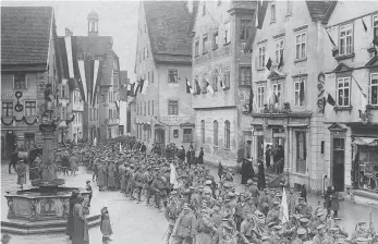  ?? FOTO/COPYRIGHT: LANDESARCH­IV BADEN-WÜRTTEMBER­G, STAATSARCH­IV SIGMARINGE­N/SUTTON VERLAG ?? Unverkennb­ar, der Sigmaringe­r Marktplatz mit Brunnen: Soldaten kehren 1918 aus dem Ersten Weltkrieg zurück.