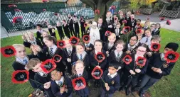  ??  ?? Pupils at Clayton’s Our Lady and St Werburgh’s Primary School with steel poppies made by KMF Metal.