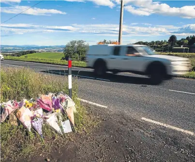  ?? Picture: Steve MacDougall. ?? Floral tributes to a crash victim are left next to the road by Tullybacca­rt Farm on the A923.