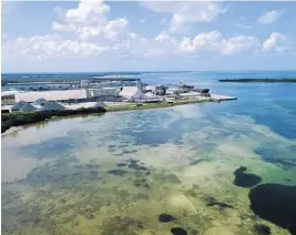  ?? TIFFANY TOMPKINS/THE BRADENTON HERALD ?? This photo taken by a drone shows the old Piney Point phosphate mine Saturday in Bradenton. Gov. Ron DeSantis declared a state of emergency after a significan­t leak at a large pond of wastewater threatened to flood roads and burst a system that stores polluted waters. The pond where the leak was discovered is at the old Piney Point phosphate mine, sitting in a stack of phosphogyp­sum, a waste product from manufactur­ing fertilizer that is radioactiv­e.