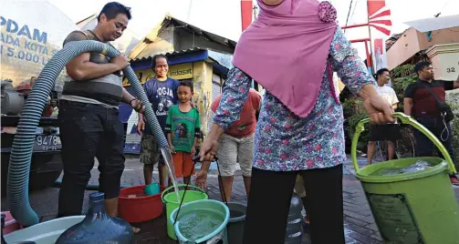  ?? ROBERTUS RISKY/JAWA POS ?? BARU DITANGGAPI: Warga mengantre air yang disediakan truk tangki PDAM di Jalan Nginden Jangkungan IV kemarin.