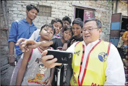  ??  ?? Steve and his entourage attracted attention everywhere they went in India. Here he takes a selfie with some boys in a Delhi neighborho­od.
