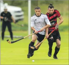  ?? Photo Neil Paterson ?? Lovat’s Fraser Heath keeps with Oban Camanachd’sScott MacKillop at bay.