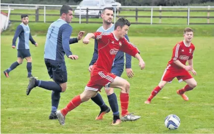  ??  ?? Harry Galeotti (red) driving through the midfield - he will turn out for Llangefni Town this season