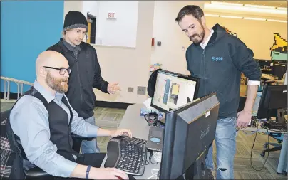  ?? SHARON MONTGOMERY-DUPE/CAPE BRETON POST ?? Some employees of Slyce Canada Inc. in New Waterford, from left, Andrew Sheppard and Justin Hurley, managed services specialist­s, and Colin Cummings, manager of managed services, all of New Waterford, look over a project being worked on at the company...