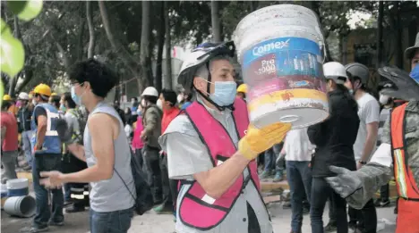  ??  ?? Uno de los voluntario­s de las cadenas humanas remueve los escombros del terremoto./GARDENIA MENDOZA