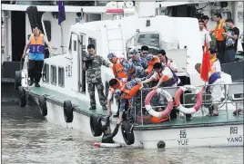  ?? REUTERS ?? Diver Guan Dong is pulled up to a boat after rescuing a crew member at the scene of a capsized cruise liner on China’s Yangtze River on Tuesday.