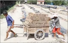  ?? PHA LINA ?? Workers move bricks through a factory in Kandal’s Muk Kampoul district late last month.