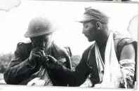  ??  ?? En såret britisk soldat deler en cigaret med en tysk krigsfange under kampen om Mareth-linjen syd for Tunesien i marts 1943. I alt blev 125.000 tyskere taget til fange.