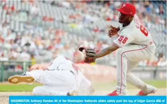  ?? AFP ?? WASHINGTON: Anthony Rendon #6 of the Washington Nationals slides safely past the tag of Edgar Garcia #66 of the Philadelph­ia Phillies after a wild pitch during the eighth inning of game one of a doublehead­er at Nationals Park in Washington. —