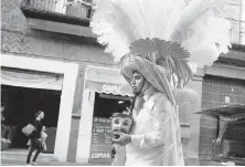  ??  ?? A performer takes a break during a dance presentati­on in the streets of Puebla.