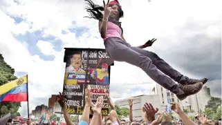  ??  ?? A supporter of Venezuela's President Nicolas Maduro is tossed into the air before the start of a march to the National Assembly for the swearing-in ceremony of the Constituti­onal Assembly, in Caracas, Venezuela, Friday. (AP)