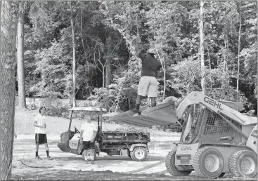  ?? Doug Walker / Rome News-Tribune ?? Bartow County Parks and Rec personnel remove hanging vines over one of the picnic sites at the new Hardin Bridge boat ramp.