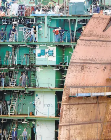  ?? ROB OSTERMAIER/DAILY PRESS FILE ?? “AMERICA BUILDS AND REPAIRS GREAT SHIPS.” This initiative’s goals include attracting more workers to local shipyards and supply shops, possibly from outside Virginia. Above, Newport News Shipbuildi­ng workers watch the superlift of a 726 ton lower bowsection of the carrier Kennedy in September.