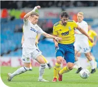  ??  ?? Leeds’ Ezgjan Alioski chalenges Maxime Colin