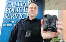  ?? GAVIN YOUNG ?? Calgary Police Service Staff Sgt. Travis Baker wears and holds the service’s Axon body camera. “We’re getting very good feedback from the membership,” says Interim Chief Steve Barlow.