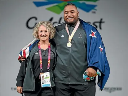  ?? SCOTT BARBOUR/ GETTY IMAGES ?? Coach Tina Ball with weightlift­ing gold medallist David Liti.