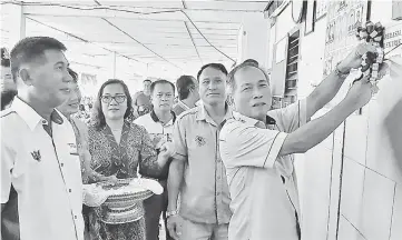  ??  ?? Salang cutting the ribbon to symbolise the commission­ing of the power supply at Rh Mambang Kana in Ng Lingah, Julau.