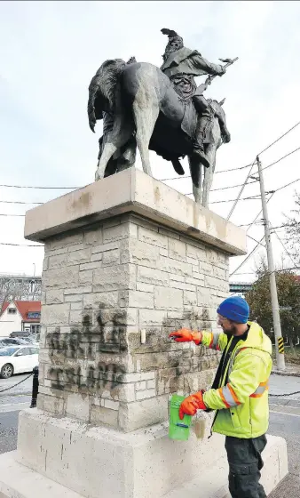  ?? NICK BRANCACCIO ?? Jeff Litfin, of Windsor Mobile Wash, works to remove spray-painted graffiti Monday from the statue of Isaac Brock and Chief Tecumseh.
