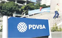  ??  ?? A man walks past a gas station with the logos of the Venezuelan state oil company PDVSA in Caracas. — Reuters photo