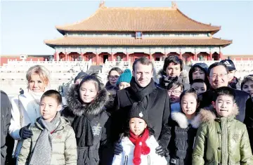  ??  ?? Macron (centre) and his wife Brigitte Macron (left) pose with Chinese and French school children during their visit to the Forbidden City, in Beijing, China. — Reuters photo