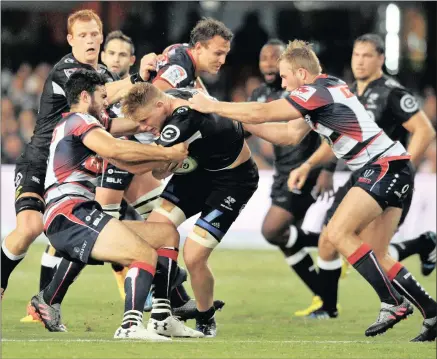  ??  ?? Daniel du Preez of the Sharks challenged by Jack Debreczni, Jack Schatz and Will Miller of the Rebels during the drawn Super Rugby match at Growth Point Stadium in Durban, last night.