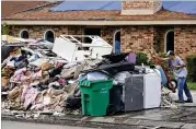  ?? GERALD HERBERT/AP ?? A resident dumps debris while gutting his flooded home in the aftermath of Hurricane Ida in Laplace, La., last week.