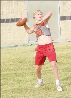  ?? Westside Eagle Observer/MIKE ECKELS ?? Senior quarterbac­k Cy Hilger draws back the ball just before releasing a throw to Coach Kelby Bohannon during the Lions’ senior high football practice in Gravette June 23. Like all high school sports teams around the state, the Lions were required to hold a light practice session with no contact exercises.