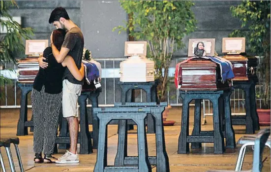  ?? LUCA ZENNARO / EFE ?? Dos parientes afectados se abrazan junto a los féretros de las víctimas antes de oficiar el entierro ordinario ayer por la tarde