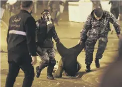  ??  ?? 0 An anti-government protester is carried away by riot police