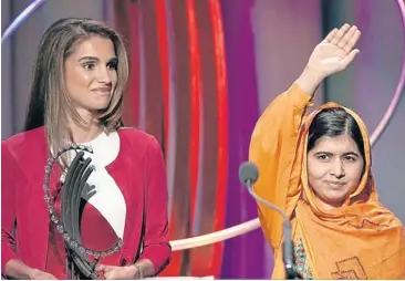  ??  ?? Malala Yousafzai, right, waves as she receives the ‘‘Leadership in Civil Society’’ award from Rania Al Abdullah, the Queen of Jordan at the Clinton Global Initiative 2013 in New York, on Wednesday.