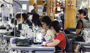  ?? —AP ?? SEATTLE: A group of workers at the C C Filson Co manufactur­ing facility work at their sewing machines, in Seattle. The Federal Reserve reported yesterday on US industrial production for September.