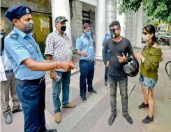  ?? — PTI ?? A special squad of civil wardens warns people to maintain social distancing at a mobile phone centre at Connaught Place in New Delhi on Thursday during antispitti­ng drive by NDMC.