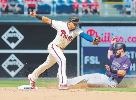  ?? Hunter Martin, Getty Images ?? Phillies second baseman Cesar Hernandez forces out Rockies center fielder David Dahl during the seventh inning Sunday on Colorado third baseman Nolan Arenado’s groundball to Philadelph­ia shortstop Jean Segura.