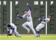  ?? AP Photo/David J. Phillip ?? ■ Los Angeles Dodgers’ Cody Bellinger catches a fly ball by Boston Red Sox’s Ian Kinsler between Enrique Hernandez and Chris Taylor during the sixth inning of Game 2 of the World Series on Wednesday.