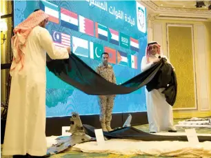  ?? AP ?? Col. Turki Al Malki, spokesman for the Saudi-led coalition, watches as officials uncover a wreckage from Iranian-Houthi drones during a press conference in Khobar, Saudi Arabia. The coalition warned Houthis of a ‘painful’ response if they continue to...