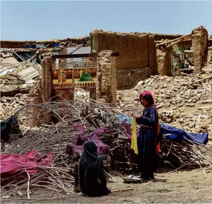  ?? Sahel Arman/afp ?? Afegãos põem suas roupas para secar em meio a escombros após terremoto no distrito de Bermal