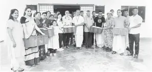  ?? ?? PRIHATIN: Lo bersama Prabu (enam kanan) serta ahli ISKCON Kuching memberi sumbangan kepada mangsa banjir di PPS Dewan Masyarakat Stapok semalam.
