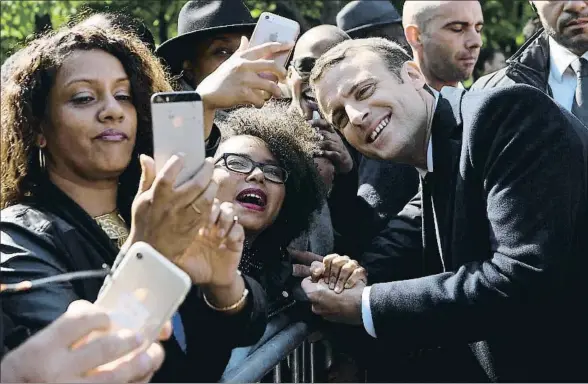  ?? POOL / REUTERS ?? Emmanuel Macron se deja fotografia­r junto a unas seguidoras al margen de un acto oficial ayer en París