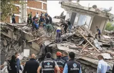  ?? Usame Are / Getty Images ?? Emergency personnel search for survivors in a building that collapsed in Izmir, Turkey’s thirdlarge­st city.