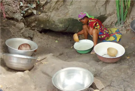  ?? PHOTO
ABUBAKAR SADIQ ISAH ?? A woman scooping water under a rock in a community at Kuje Area Council recently.