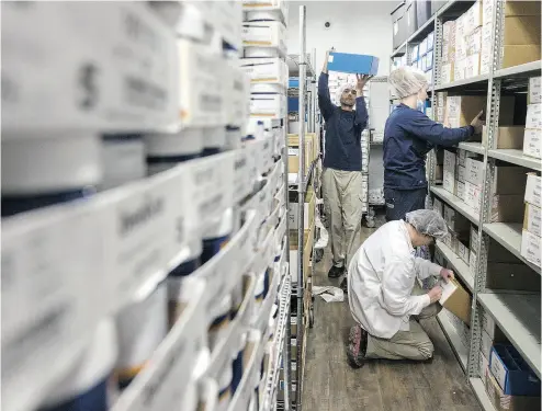  ?? CHRIS ROUSSAKIS / BLOOMBERG ?? Employees sorts boxes containing marijuana at the Canopy Growth Corp. facility in Smiths Falls, Ont. Aurora was one of the Canadian cannabis firms whose stocks plunged on Thursday. The pullback isn’t causing too much concern among analysts, many of...