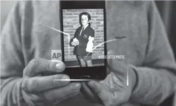  ?? ASSOCIATED PRESS ?? Rufino Varela shows a portrait of himself on his cell phone when he was 9-year-old, during his first communion ceremony in 1974 at the Cardenal Newman school in Buenos Aires, Argentina.