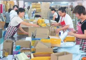  ?? WANG BIAO / FOR CHINA DAILY ?? Staff at an e-commerce company in Fuyang, Anhui province, pack products ahead of the shopping carnival on June 18.
