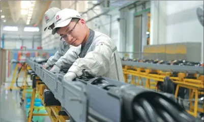  ?? ZHANG JINGANG / FOR CHINA DAILY ?? CRRC employees operate an assembly line of the company in Qingdao, Shandong province.