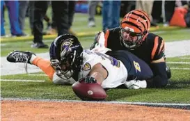  ?? JEFF DEAN/AP ?? Ravens running back J.K. Dobbins scores while being tackled by Bengals linebacker Markus Baile in the first half of Sunday night’s playoff game in Cincinnati.